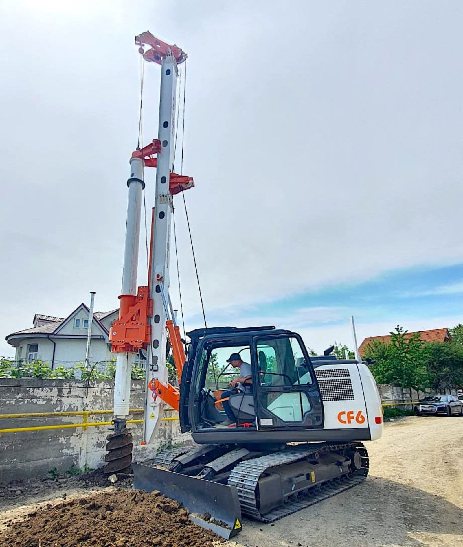 Compact piling rig drilling near existing structures on a construction site